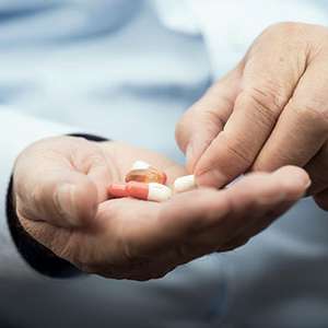 Man's hands holding pills
