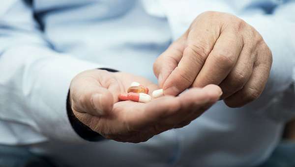 Man's hands holding pills