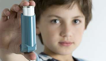 Child with inhaler referencing asthma